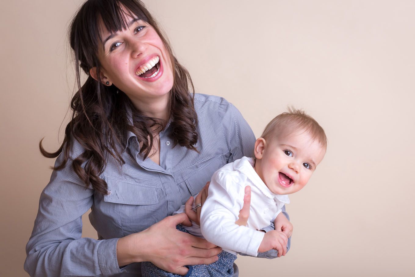 Portrait of a little girl and her mum in a studio with backdrop and lighting equipment